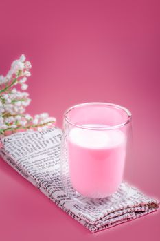 Summer drink concept. Strawberry pink milk with froth milk in clear glass on pink background. 