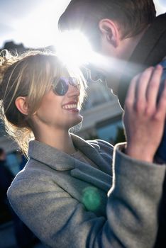 Happy playful couple in sunglasses in love dating joking and laughing in the street