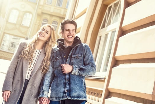 Young laughing couple enjoying sunny mood and having fun