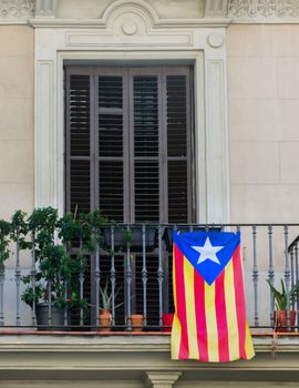 Facade of a building with flag of Catalonia in balcony Barcelona city