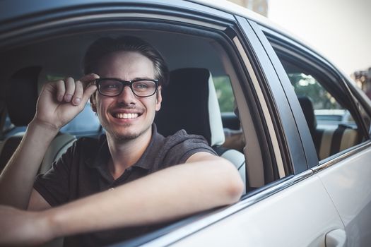 Enjoy the drive. Image of young handsome guy sitting in car.
