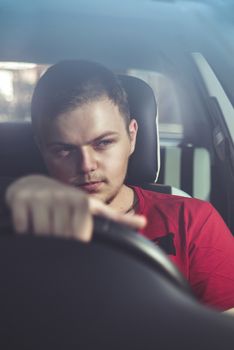 Portrait of an handsome guy driving his car