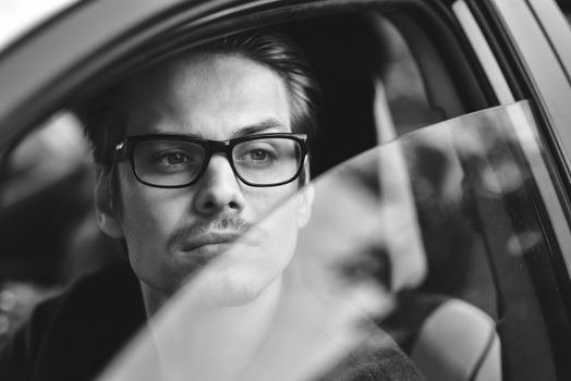 Enjoy the drive. Image of young handsome guy sitting in car.
