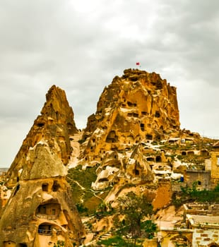 Uchisar castle rock, Turkey. Rural Cappadocia Mountain landscape panoramic view. Stone houses