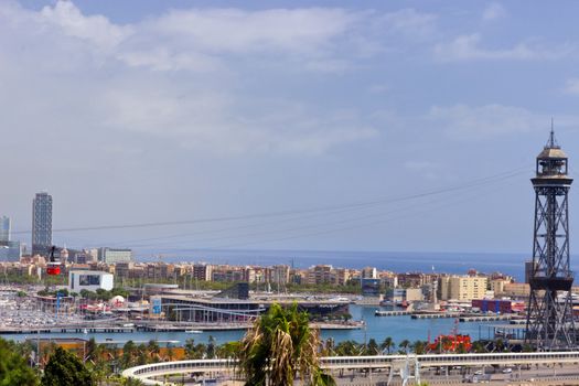 BARCELONA, SPAIN - AUGUST 27, 2012: Rambla del Mar, passenger port of barcelona and tower with a rope-way with an area of sports boats, dock and a shopping area. Catalonia, Spain.