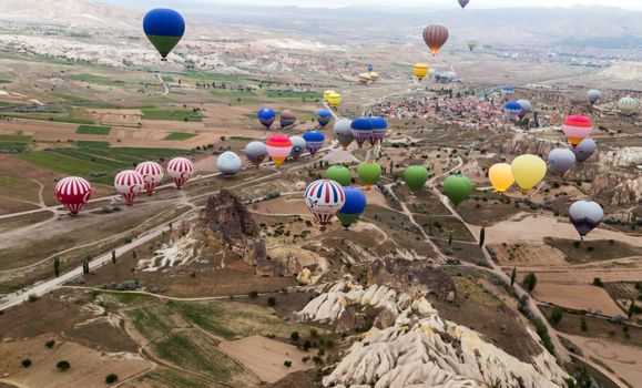 GOREME, TURKEY - MAY 08, 2014 : Hot air balloon flying over rock landscape, attraction of Cappadocia is an air flight. village location, Turkey, Asia.