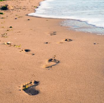 Foot prints on a gold sandy beach