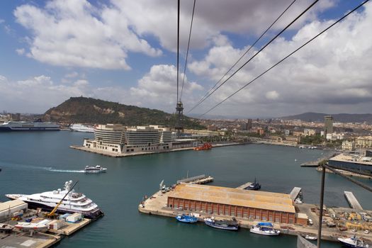BARCELONA, SPAIN - AUGUST 27, 2012: Passenger port of barcelona and tower with a rope-way with an area of sports boats, dock and a shopping area. Catalonia, Spain.