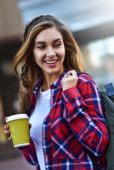 Awesome girl in urban style walk in city with coffee.