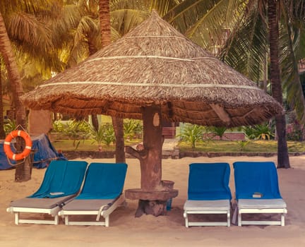 Blue sunbeds Deckchairs, umbrella and chair, parasol on the tropical sand beach
