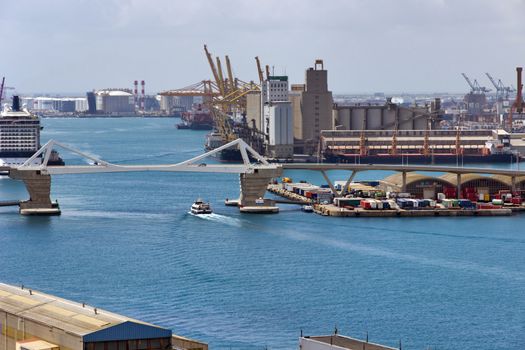 BARCELONA, SPAIN - AUGUST 27, 2012: Terminal Port Nou, Сontainer ship in import export and business logistic, By crane, Trade Port, Ship, cargo to harbor Barcelona. Catalonia, Spain.