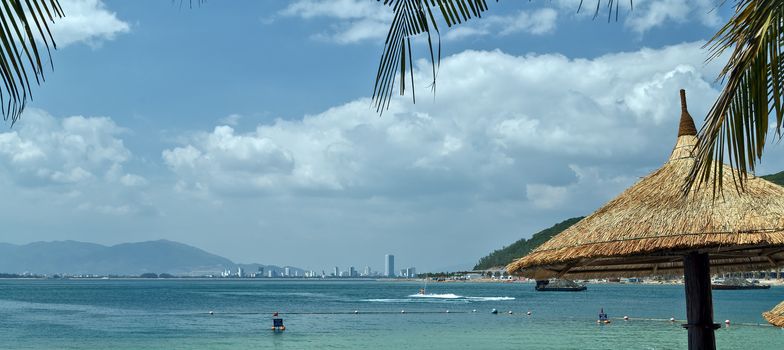 Sunbeds and umbrellas on the paradise white sand Vinpearl beach of Nha Trang Bay of South China Sea, Vietnam.
