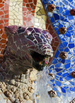 Head snake Fountain Flag Catalonia ceramic tile background covered with tile-shard mosaic, Parc Guell designed by Antoni Gaudi located on Carmel Hill, Barcelona, Spain.