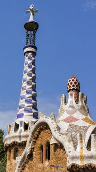 Gingerbread house ceramic tile grunge background covered with tile-shard mosaic, Parc Guell designed by Antoni Gaudi located on Carmel Hill, Barcelona, Spain.
