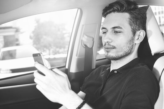 Businessman texting on his mobile phone while driving. Dangerous driver.