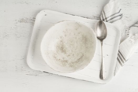 an empty and clean ceramic bowl and spoon on a table