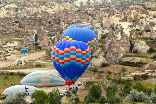 Hot air balloon flying over rock landscape, attraction of Cappadocia is an air flight. village location, Turkey, Asia.