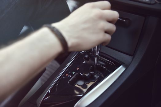 Hand Holding Automatic Transmission In his Car