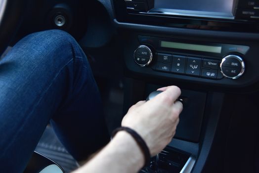 Hand Holding Automatic Transmission In his Car