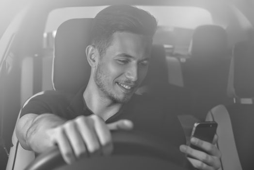 Businessman texting on his mobile phone while driving. Dangerous driver.