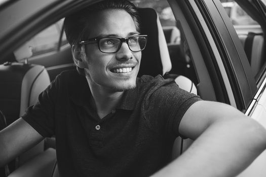 Enjoy the drive. Image of young handsome guy sitting in car.