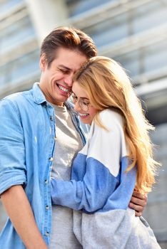 Beautiful couple in love dating outdoors and smiling. Beautiful girl embraces the guy
