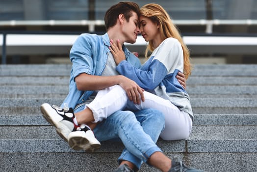 Happy to spending time together. Young beautiful couple outdoor fashion portrait. Attractive boy and girl hugging and kissing.