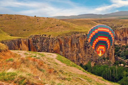Hot air balloons landing mountain in national park Canyon Ihlara, Cappadocia, Turkey ballooning