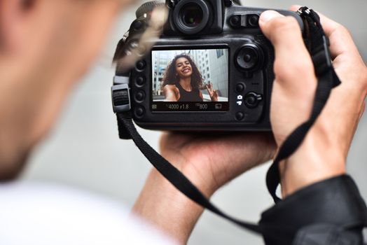 Digital single-lens reflex camera in hands. Photographer shooting hands close up. Man photographer makes photos for stock photography. Male hands hold the camera close-up