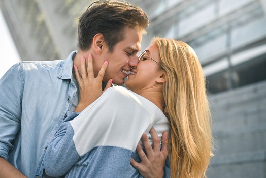 Young beautiful couple outdoor fashion portrait. Attractive boy and girl hugging and kissing.