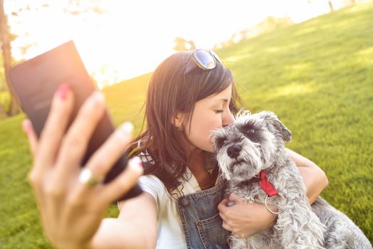 Portrait of a happy caucasian woman who hugs her beloved dog and Makes selfie with him .The concept of love for animals. best friends. Dog breed Schnauzer