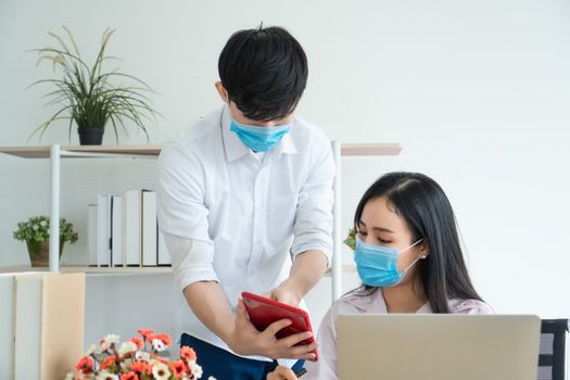 Asian men and women wear medical masks, work from home. Is a distance from society To prevent the spread of Coronavirus