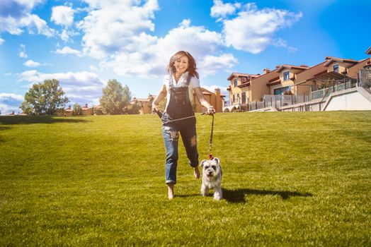 Adult Caucasian happy woman run in the park with her beloved dog Schnauzer. fun mood