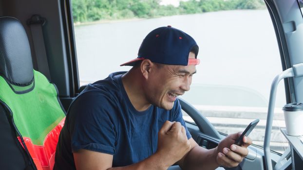 Asian truck drivers are using their smartphones to communicate happily in the car. Fast, fast wireless communication with high-speed internet.