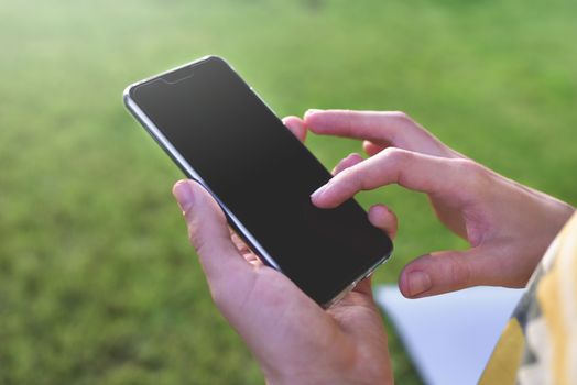 Close up view of male hands typing text message outdoors