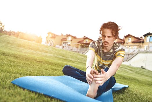 Man performing yoga young fitness man outdoor doing exercise