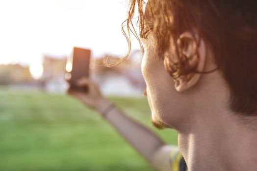 close-up guy takes pictures of nature, beautiful views on his smartphone. summer mood