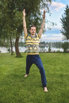 Man performing yoga young fitness man outdoor doing exercise. leg stretch