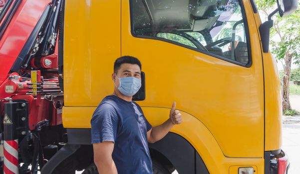 Close-up photos of Asian truck drivers wearing masks to protect against dust and the spread of the flu. Covid 19. Inside the car front