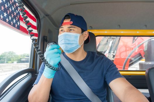 Close-up photos of Asian truck drivers wearing masks to protect against dust and the spread of the flu. Covid 19. Inside the car front