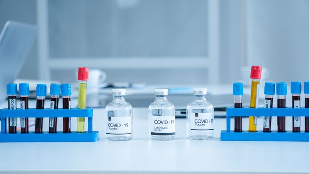 The Corona Virus Vaccine is placed on a scientist's desk in a medical laboratory. Scientists are working on a vaccine to treat patients with emerging infectious diseases.