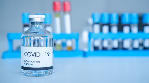 The Corona Virus Vaccine is placed on a scientist's desk in a medical laboratory. Scientists are working on a vaccine to treat patients with emerging infectious diseases.