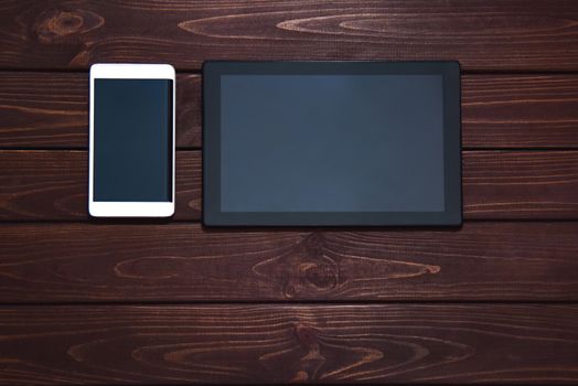 modern smart phone and tablet pc on wooden table. technology concept. free copyspace
