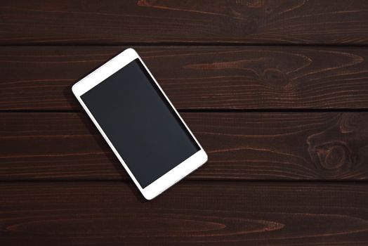 Mobile phone on wooden table background. Smartphone on wood old plank vintage texture background. top view