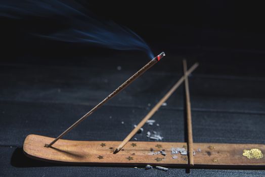 smoldering aromatic stick in the dark, a lot of smoke