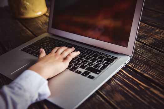 Person working on a modern laptop on a wooden bench