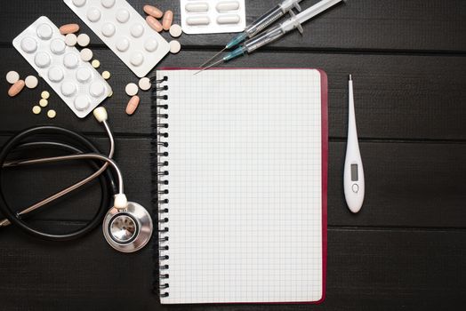 Medication prescription with pills and stethoscope lies on wooden table. Tablet or drug. Medicine and healthy concept. Copy space for text. Close-up. Indoors.