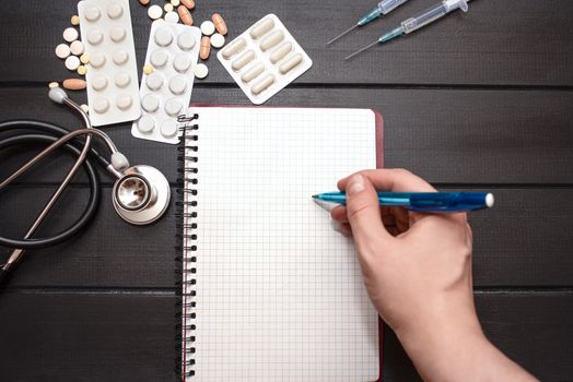 Medication prescription with pills and stethoscope lies on wooden table. Tablet or drug. Medicine and healthy concept. Copy space for text. Close-up. Indoors.