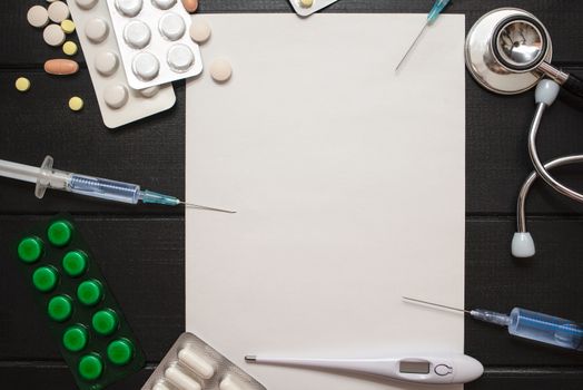 Medication prescription with pills and stethoscope lies on wooden table. Tablet or drug. Medicine and healthy concept. Copy space for text. Close-up. Indoors.