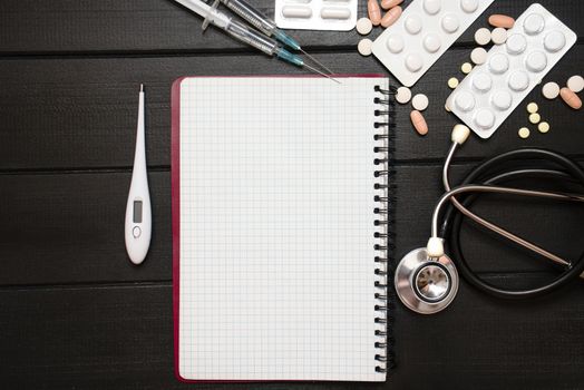 Medication prescription with pills and stethoscope lies on wooden table. Tablet or drug. Medicine and healthy concept. Copy space for text. Close-up. Indoors.